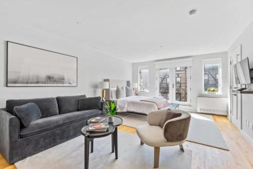 a living room with a couch and a bed at Luxe Studio with Charming Juliet Balcony in New York