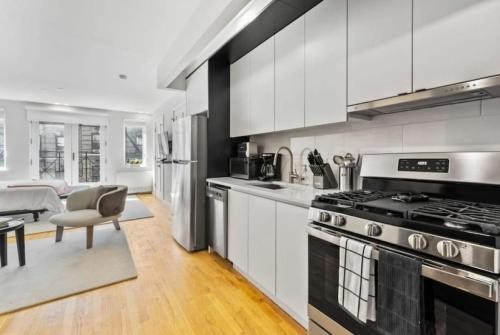 a kitchen with white cabinets and a stove at Luxe Studio with Charming Juliet Balcony in New York