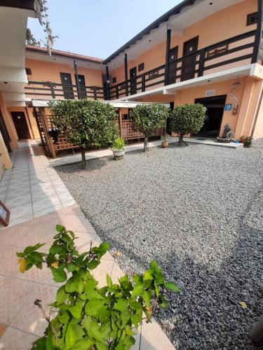 a courtyard of a building with trees and gravel at Pousada Água da Fonte in Florianópolis