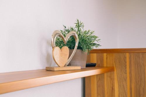 a wooden heart on a shelf with a plant at Kiechlhof in Patsch