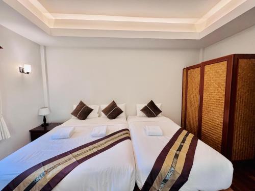 two beds in a room with white walls at Lamai Bayview Boutique Resort in Lamai