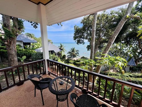 a balcony with chairs and a table and the ocean at Lamai Bayview Boutique Resort in Lamai
