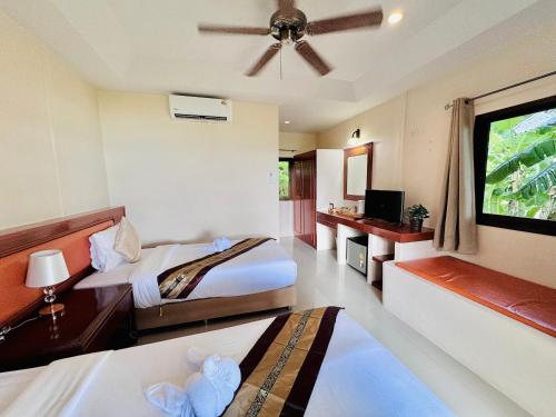 a hotel room with two beds and a flat screen tv at Lamai Bayview Boutique Resort in Lamai