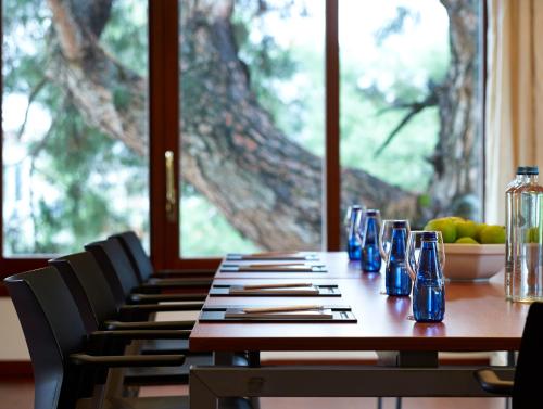 a wooden table with chairs and blue bottles on it at Grand Serai Congress and Spa in Ioannina