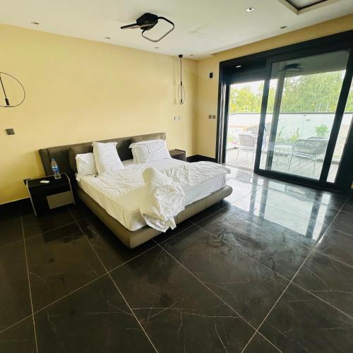 a bedroom with a bed with white sheets and pillows at Villa Palm évasion in Ngaparou