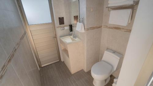 a small bathroom with a toilet and a sink at Hotel Quirasco in Xalapa