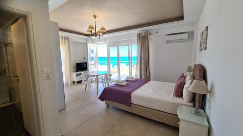 a bedroom with a bed and a view of the ocean at Bella Mare Luxury Apartments in Kalamaki Heraklion