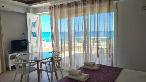 a bedroom with a table and a view of the ocean at Bella Mare Luxury Apartments in Kalamaki Heraklion