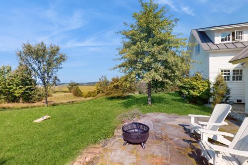 a backyard with a grill and two white chairs at Cider Hill Haven in New Haven
