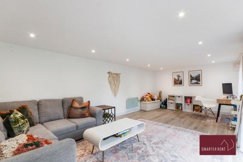 a living room with a couch and a table at Guildford - 4 Bedroom House - Private Parking in Guildford