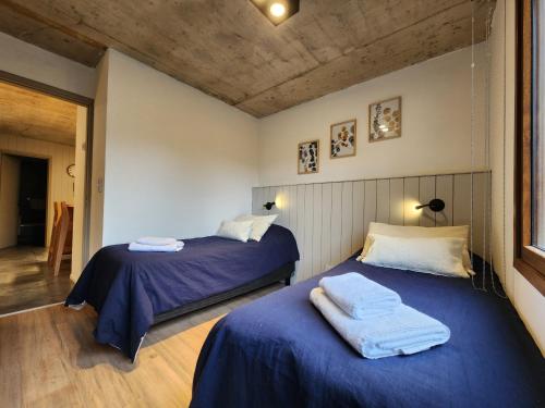 - une chambre avec 2 lits avec des draps bleus dans l'établissement Alamos de los Andes ExtraL - Andarlibre, à San Martín de los Andes