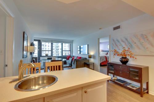 a kitchen with a sink and a living room at Alexander 1209 Beachfront condo with 2 pools , beach access, sauna, stores in Miami Beach
