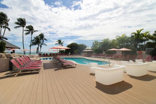 a pool with chaise lounge chairs and a bunch ofituresitures at Alexander 1209 Beachfront condo with 2 pools , beach access, sauna, stores in Miami Beach