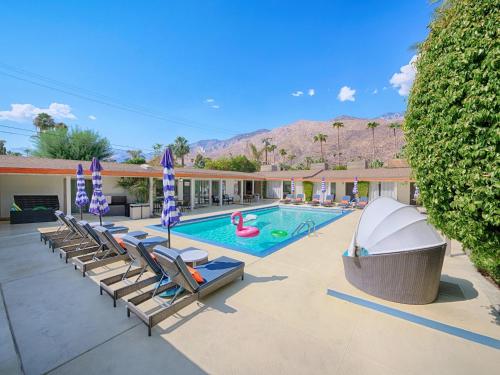 a swimming pool with lounge chairs and a resort at Little Paradise Hotel in Palm Springs