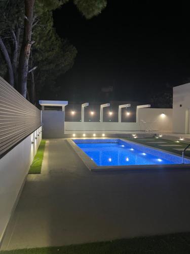 a swimming pool in a backyard at night at Pervolia Oasis Villa in Kiti