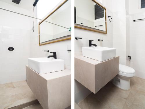 Un baño con dos lavabos y un inodoro. en Adhoc Cintermex, en Monterrey