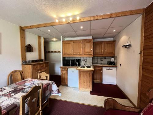 - une cuisine avec des placards en bois et une table dans une pièce dans l'établissement Résidence Saint Jacques B - 3 Pièces pour 8 Personnes 48, à Mâcot La Plagne