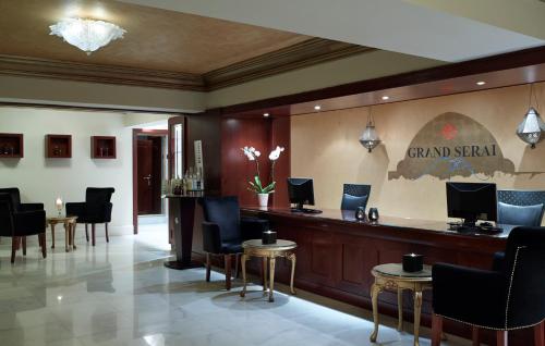 a lobby with a bar with chairs and tables at Grand Serai Congress and Spa in Ioannina