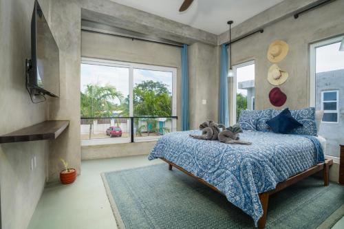 a bedroom with a bed with a teddy bear on it at Oceanfront 3 Bedroom - Conmigo Villas South in Maya Beach
