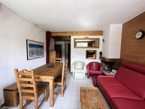 un salon avec un canapé rouge et une table dans l'établissement Résidence Saint Jacques B - 3 Pièces pour 7 Personnes 51, à Mâcot La Plagne