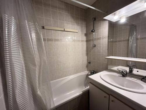 une salle de bain avec un lavabo et un rideau de douche dans l'établissement Résidence Saint Jacques B - 3 Pièces pour 7 Personnes 51, à Mâcot La Plagne