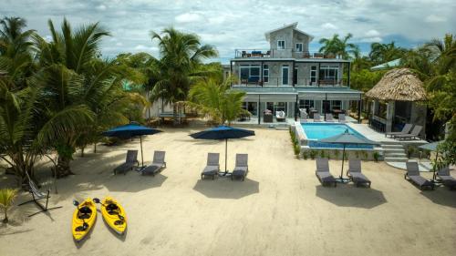 an aerial view of a resort with a kayak on the beach at Oceanfront 3 Bedroom - Conmigo Villas North in Maya Beach