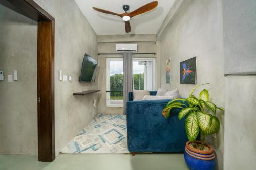 a living room with a couch and a ceiling fan at Oceanfront 3 Bedroom - Conmigo Villas North in Maya Beach