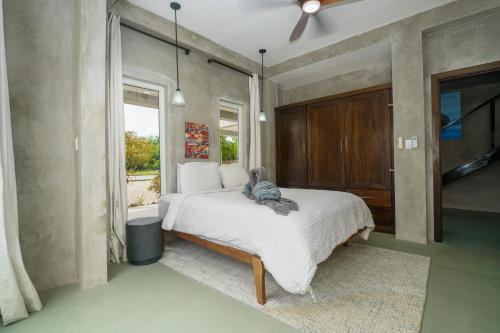 a bedroom with a bed with a stuffed animal on it at Oceanfront 3 Bedroom - Conmigo Villas North in Maya Beach