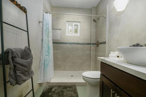 a bathroom with a shower and a toilet and a sink at Oceanfront 3 Bedroom - Conmigo Villas North in Maya Beach