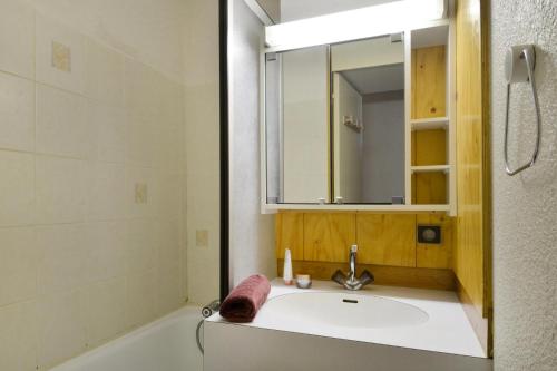 une salle de bain avec un lavabo, une baignoire et un miroir dans l'établissement Résidence Comete - 2 Pièces pour 5 Personnes 63, à Mâcot La Plagne