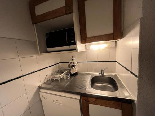 une cuisine avec un évier et un micro-ondes dans l'établissement Résidence Saint Jacques B - 2 Pièces pour 5 Personnes 71, à Mâcot La Plagne