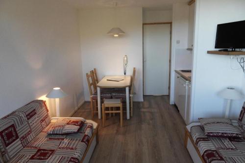Cette petite chambre comprend une table, une table et des chaises. dans l'établissement Résidence Licorne - Studio pour 4 Personnes 99, à Mâcot La Plagne