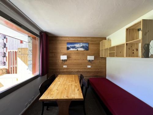 Cette chambre dispose d'une table et de chaises en bois ainsi que d'une fenêtre. dans l'établissement Résidence Beryl - Studio pour 5 Personnes 23, à Mâcot La Plagne