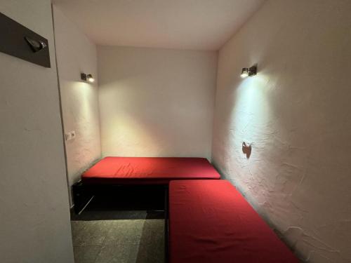 un banc rouge dans une pièce dotée d'un mur avec des lumières dans l'établissement Résidence Beryl - Studio pour 5 Personnes 23, à Mâcot La Plagne