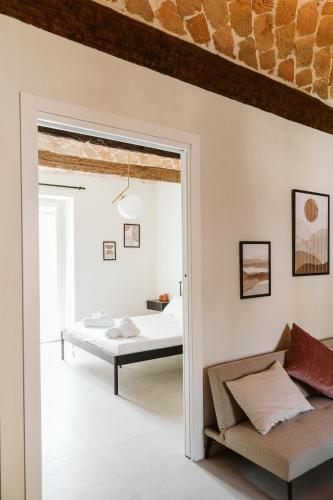 a bedroom with a bed and a couch at Vicolo Al Castello - Langhe e Monferrato Suites in Costigliole dʼAsti