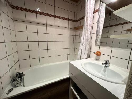 une salle de bain avec une baignoire blanche et un lavabo dans l'établissement Residence 3000 Bail - Studio pour 4 Personnes 34, à Aime La Plagne