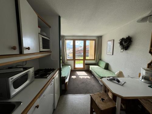- une cuisine avec un canapé et une table dans une chambre dans l'établissement Résidence Andromede - Studio pour 4 Personnes 35, à Mâcot La Plagne