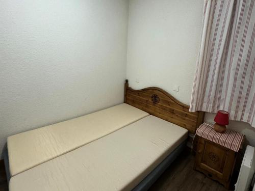 - un petit lit dans une petite pièce avec rideau dans l'établissement Résidence Carene - 2 Pièces pour 5 Personnes 24, à Mâcot La Plagne