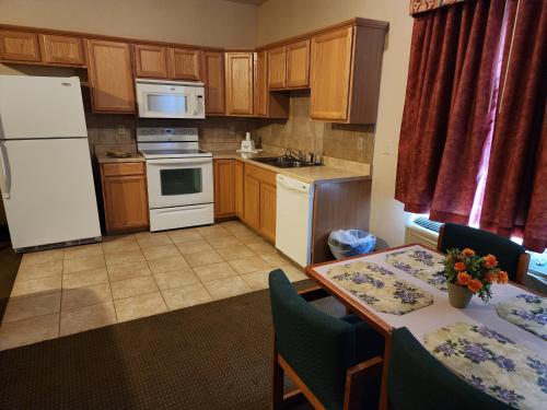 a kitchen with a white refrigerator and a table with chairs at Days Inn by Wyndham Luray Shenandoah in Luray