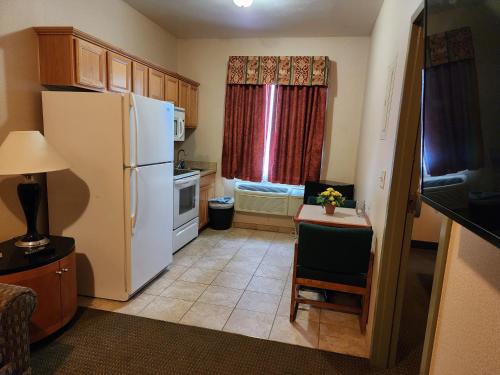 a small kitchen with a white refrigerator and a table and chair at Days Inn by Wyndham Luray Shenandoah in Luray