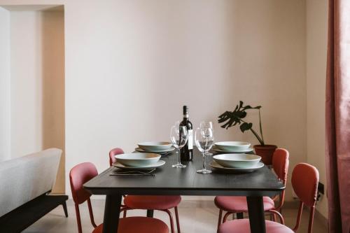 a black table with plates and wine glasses on it at Vicolo Al Castello - Langhe e Monferrato Suites in Costigliole dʼAsti