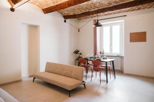 a living room with a table and chairs and a couch at Vicolo Al Castello - Langhe e Monferrato Suites in Costigliole dʼAsti