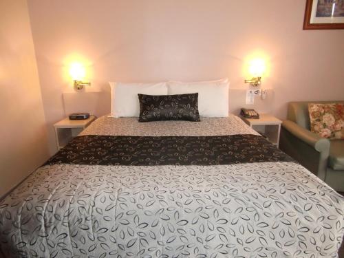 Castle Motel Bairnsdale في بيرنسدال: غرفة نوم بسرير كبير وأريكة