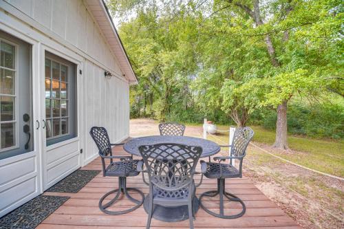 a patio with a table and chairs on a porch at Rural Spiro Getaway with Private Deck! in Pocola