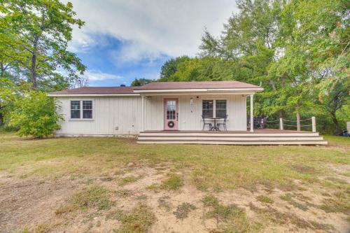 a white house with a porch and a yard at Rural Spiro Getaway with Private Deck! in Pocola