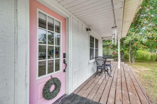a house with a pink door and a chair on a porch at Rural Spiro Getaway with Private Deck! in Pocola