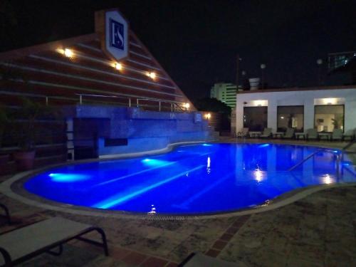 a large blue swimming pool in front of a building at night at EXECUTIVE SUITES VALENCIA in Valencia