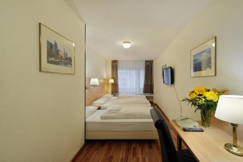 a hotel room with a bed and a desk at Bellevue Hotel in Düsseldorf