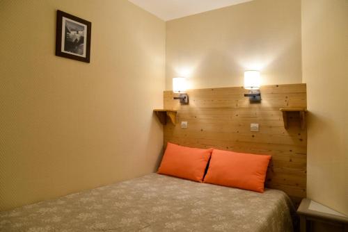 Cette chambre comprend un lit avec deux lampes murales. dans l'établissement Résidence Licorne - 2 Pièces pour 5 Personnes 534, à Mâcot La Plagne