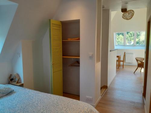 - une chambre avec un lit et un placard jaune dans l'établissement La Charretterie Cœur du village typique Normand, à Saint-Christophe-sur-Condé